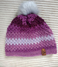 Beanie with pompom, shades of purple.