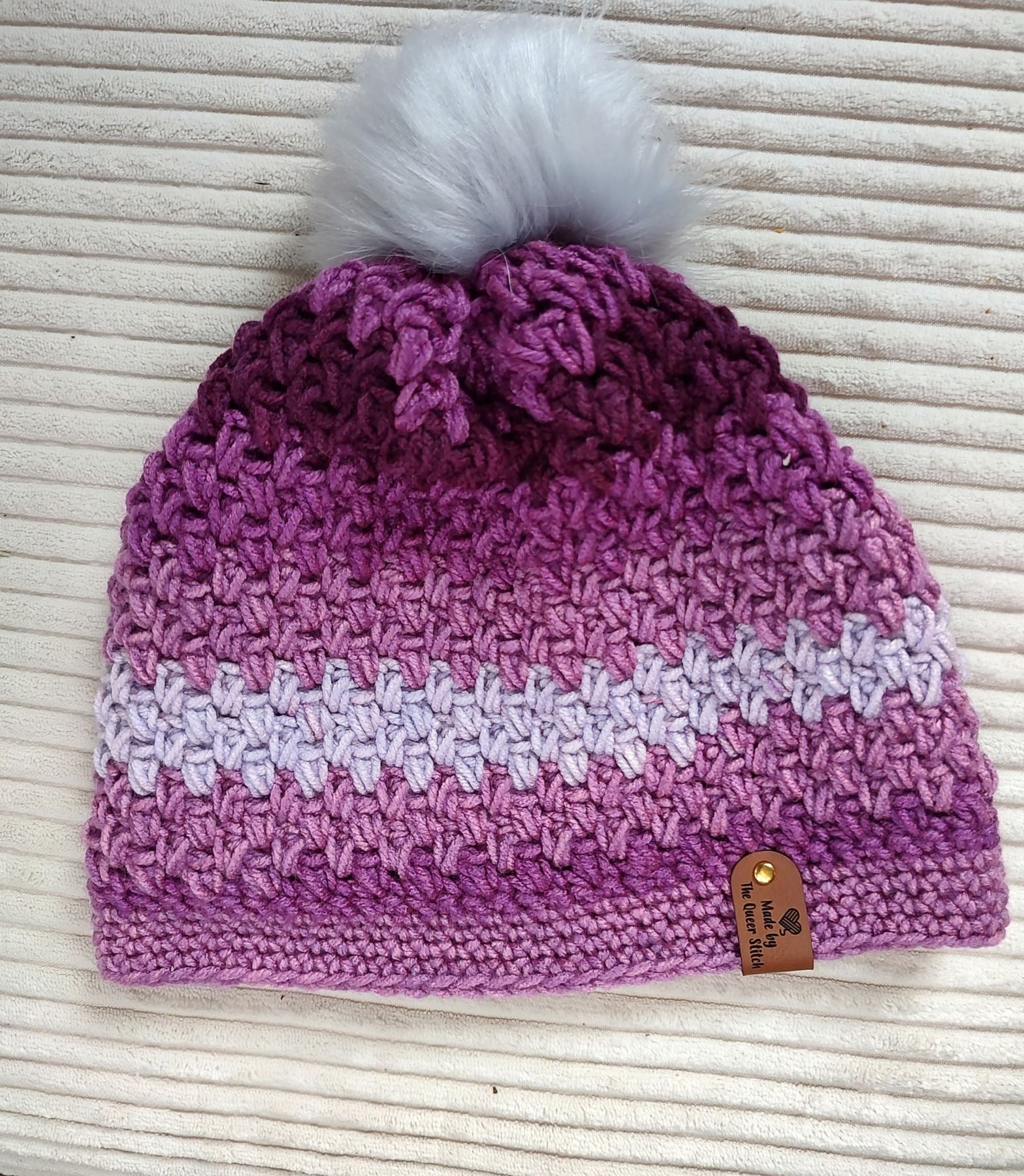 Beanie with pompom, shades of purple.